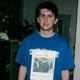 A portrait of the author, aged 17, in a shirt he wore regularly: a Cabaret shirt from a high school production, with a photo of police from the 1999 Seattle WTO protests printed out and taped over it. The handwritten caption reads “Corporate Storm Troopers.” Photo courtesy of Matthew Hardigree.